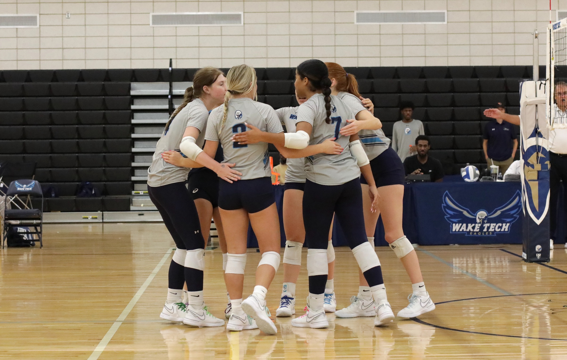 Wake Tech Volleyball team huddle after scoring a point.